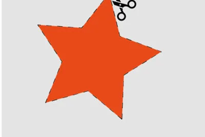 Schere schneidet roten Stern aus